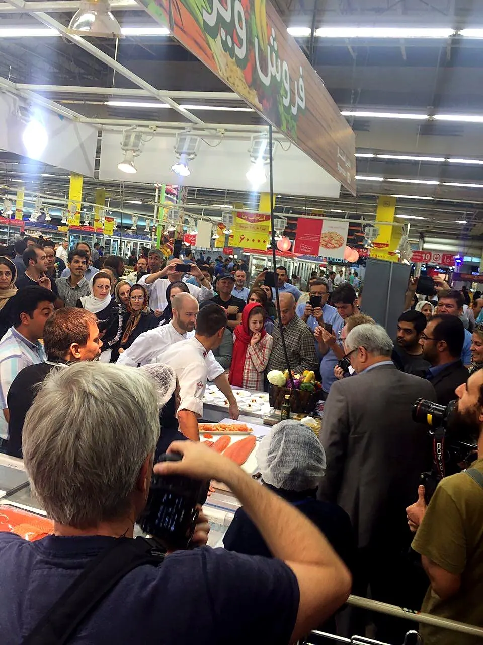 A crowd gathered around a live seafood demonstration