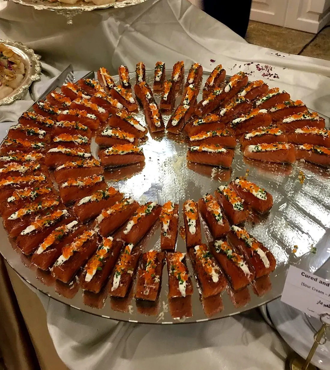 A platter of cured salmon bites topped with crème fraîche, chives and roe